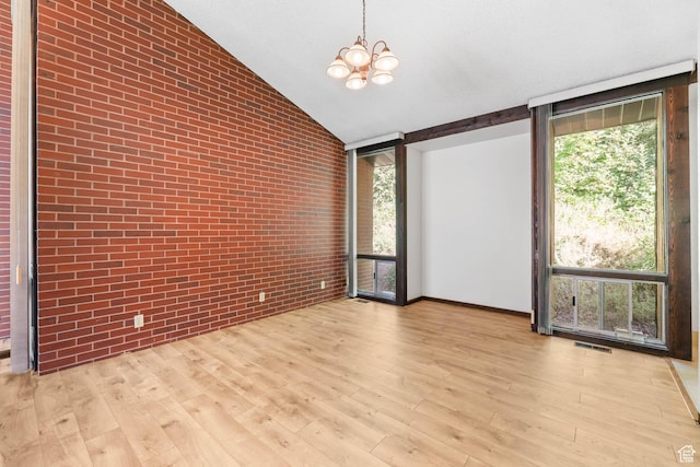 3574 E Kings Cove Way, Cottonwood Heights, UT 84121 - unfurnished room featuring wood finished floors, a chandelier, brick wall, and vaulted ceiling