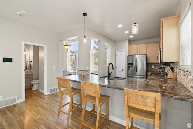 3584 S Autumn Gate Ct, Magna, UT 84044 - kitchen with appliances with stainless steel finishes, a peninsula, light wood-style flooring, plenty of natural light, and recessed lighting