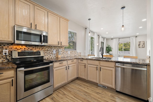 3584 S Autumn Gate Ct, Magna, UT 84044 - kitchen with stainless steel appliances, light brown cabinets, a peninsula, tasteful backsplash, and light wood-style flooring