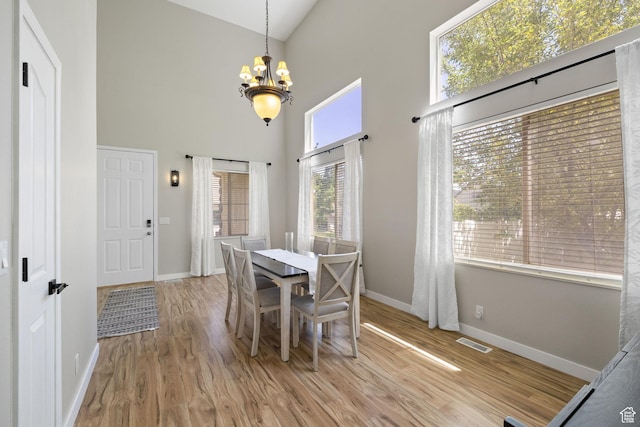 3584 S Autumn Gate Ct, Magna, UT 84044 - dining room featuring a chandelier, a towering ceiling, and wood finished floors