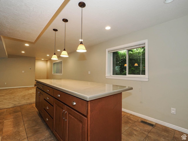 1473 E Millcreek Way, Millcreek, UT 84106 - kitchen with dark tile patterned floors, light countertops, a kitchen island, pendant lighting, and recessed lighting