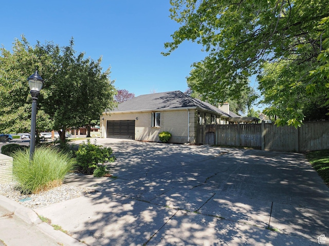 1473 E Millcreek Way, Millcreek, UT 84106 - view of side of property with driveway, an attached garage, and brick siding