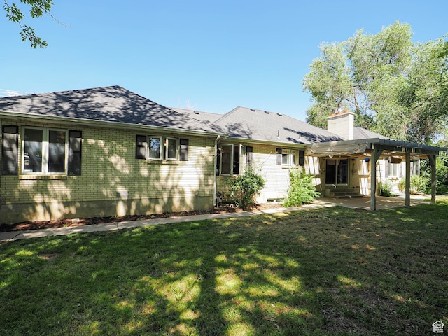 1473 E Millcreek Way, Millcreek, UT 84106 - back of house with a patio area, a chimney, a lawn, and brick siding
