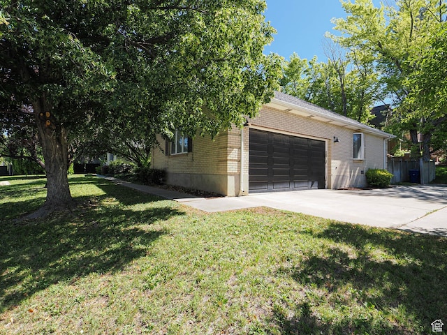 1473 E Millcreek Way, Millcreek, UT 84106 - view of home's exterior with brick siding, an attached garage, concrete driveway, and a lawn