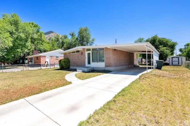 819 E 1100 N, Ogden, UT 84404 - view of front facade with a storage unit, brick siding, driveway, and a carport