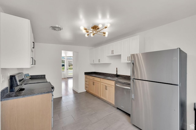819 E 1100 N, Ogden, UT 84404 - kitchen featuring appliances with stainless steel finishes, a chandelier, dark countertops, and white cabinetry
