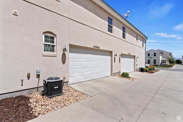 10606 S Redknife Dr, South Jordan, UT 84009 - view of side of home featuring driveway, stucco siding, and a garage