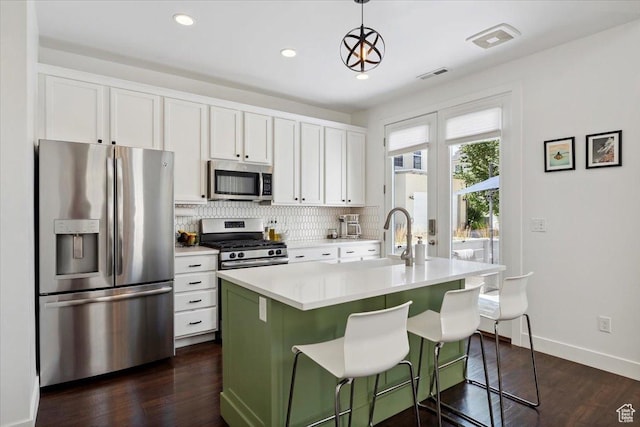 10606 S Redknife Dr, South Jordan, UT 84009 - kitchen featuring stainless steel appliances, backsplash, white cabinets, dark wood-style flooring, and light countertops