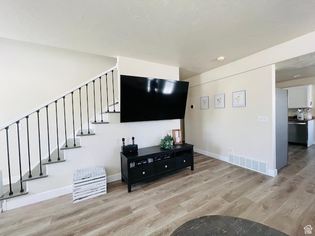 908 W Timpie Rd S, Tooele, UT 84074 - living area with light wood-style flooring and stairway