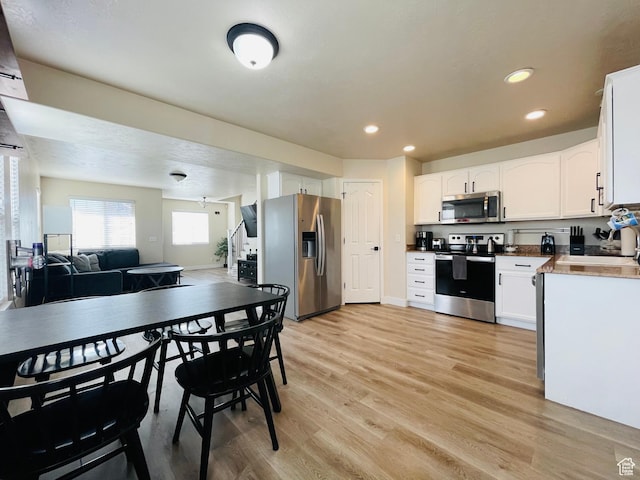 908 W Timpie Rd S, Tooele, UT 84074 - kitchen with appliances with stainless steel finishes, light wood-style floors, white cabinetry, open floor plan, and recessed lighting