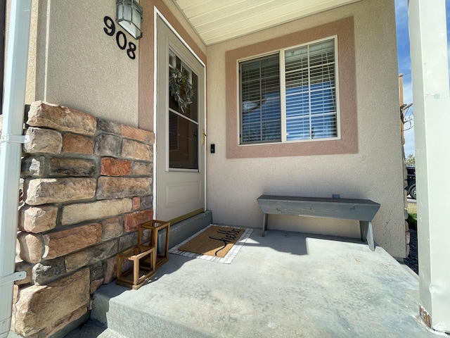 908 W Timpie Rd S, Tooele, UT 84074 - view of exterior entry featuring covered porch, stucco siding, and stone siding