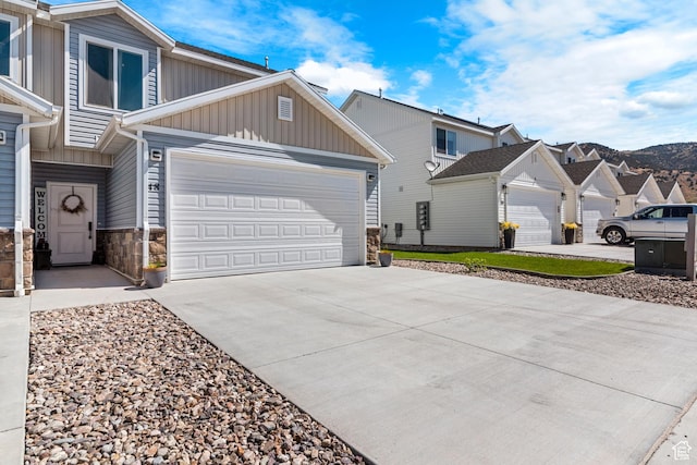 48 E Cedar Ln, Malad City, ID 83252 - view of front of property featuring board and batten siding, driveway, stone siding, and a garage
