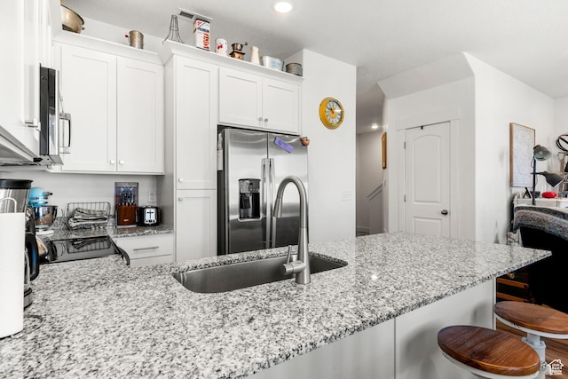 48 E Cedar Ln, Malad City, ID 83252 - kitchen with appliances with stainless steel finishes, a kitchen bar, white cabinetry, and recessed lighting