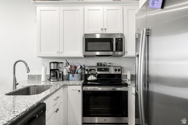 48 E Cedar Ln, Malad City, ID 83252 - kitchen featuring stainless steel appliances, white cabinets, and light stone countertops
