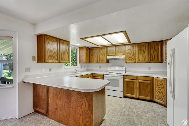 2386 N 725 W, Layton, UT 84041 - kitchen featuring white appliances, under cabinet range hood, a peninsula, brown cabinets, and light countertops