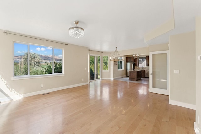 2886 N Desert Forest Ln, Lehi, UT 84043 - unfurnished living room featuring a chandelier and light wood-style floors
