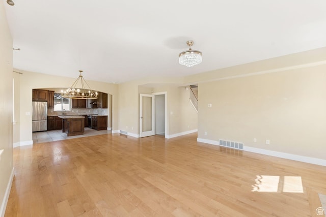 2886 N Desert Forest Ln, Lehi, UT 84043 - unfurnished living room with a chandelier and light wood-style floors