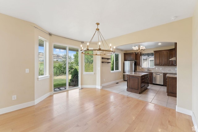 2886 N Desert Forest Ln, Lehi, UT 84043 - kitchen with stainless steel appliances, a chandelier, a center island, light wood-style flooring, and dark brown cabinetry