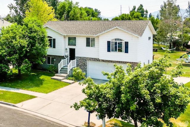 232 Sunstone Cir W, Logan, UT 84321 - split foyer home featuring brick siding, concrete driveway, a front lawn, and a garage