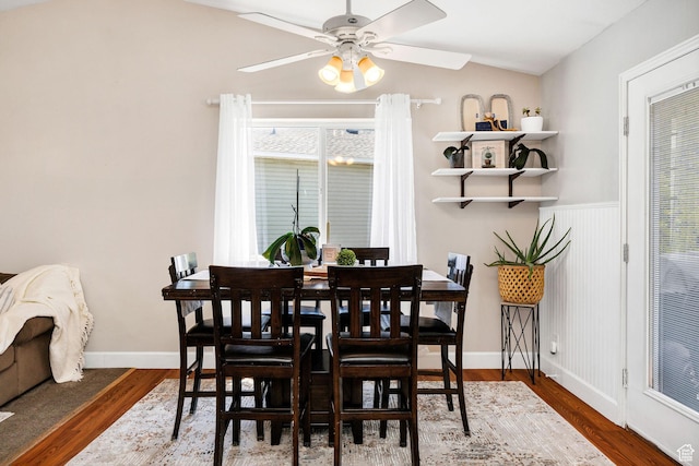232 Sunstone Cir W, Logan, UT 84321 - dining space featuring ceiling fan, wood finished floors, vaulted ceiling, and a wainscoted wall