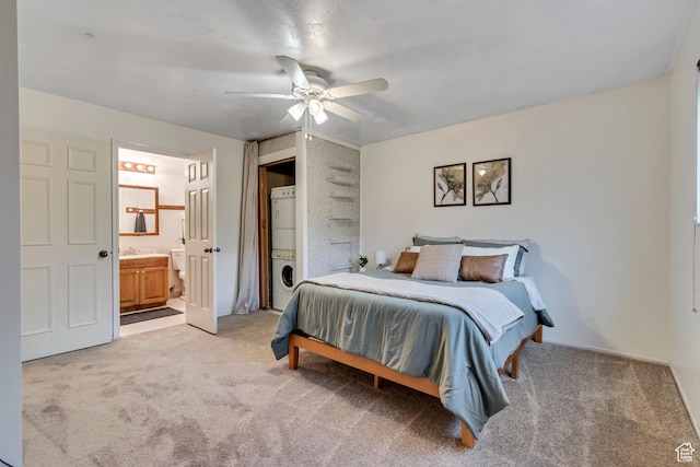 6074 W Wending Ln, West Valley City, UT 84128 - bedroom with estacked washer and dryer, light colored carpet, ensuite bath, and a ceiling fan