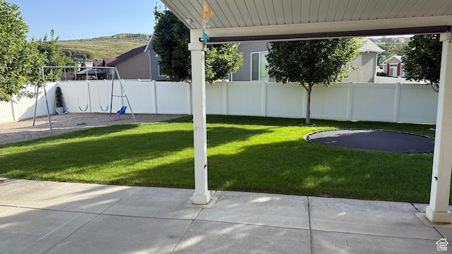 559 E Petersen Pkwy, South Weber, UT 84405 - fenced backyard with a patio area, a playground, and a trampoline