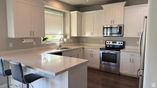 559 E Petersen Pkwy, South Weber, UT 84405 - kitchen featuring appliances with stainless steel finishes, a peninsula, dark wood-style flooring, and white cabinetry
