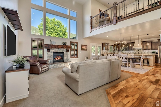 789 Eliza Ct, Farmington, UT 84025 - living room featuring a stone fireplace, a high ceiling, light wood-type flooring, a chandelier, and recessed lighting