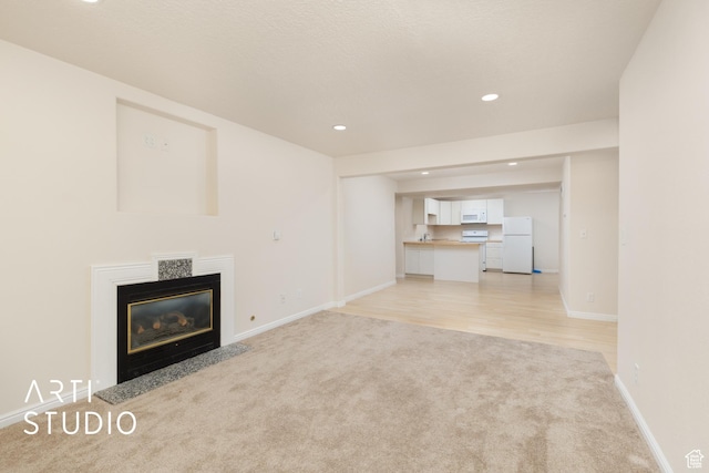 796 N 200 W, American Fork, UT 84003 - unfurnished living room featuring light carpet, recessed lighting, a fireplace with flush hearth, and light wood finished floors