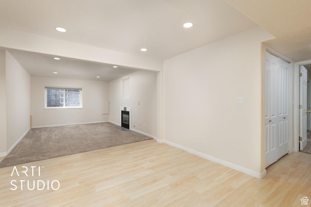 796 N 200 W, American Fork, UT 84003 - unfurnished living room with light wood-style flooring, recessed lighting, and a glass covered fireplace