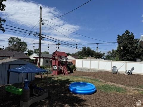 4371 S 200 W, Washington Terrace, UT 84405 - fenced backyard with a storage shed and a playground