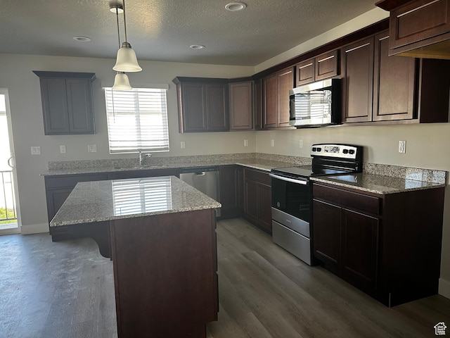 12343 S Varitek Dr, Herriman, UT 84096 - kitchen with appliances with stainless steel finishes, a center island, wood finished floors, light stone countertops, and plenty of natural light
