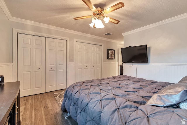 3161 S 8520 W, Magna, UT 84044 - bedroom featuring light wood finished floors, multiple closets, a wainscoted wall, ceiling fan, and ornamental molding