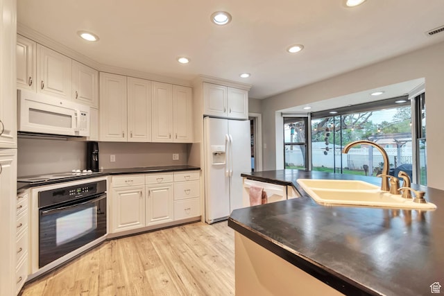3161 S 8520 W, Magna, UT 84044 - kitchen with white appliances, light wood-style floors, dark countertops, white cabinetry, and recessed lighting