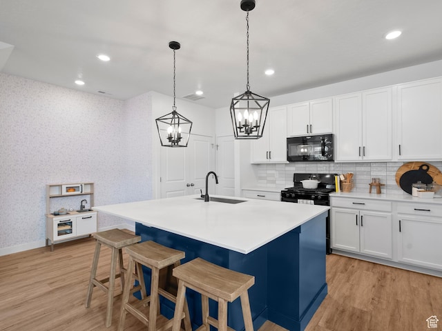 132 E Geyser Ct, Saratoga Springs, UT 84045 - kitchen featuring black appliances, a chandelier, light wood-style flooring, decorative backsplash, and recessed lighting