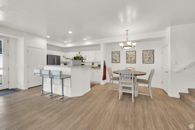3908 W Lorient Ave, West Jordan, UT 84084 - kitchen featuring freestanding refrigerator, a chandelier, white cabinets, light wood finished floors, and a center island
