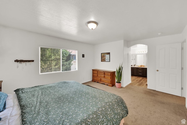 3908 W Lorient Ave, West Jordan, UT 84084 - bedroom featuring arched walkways, light carpet, and connected bathroom