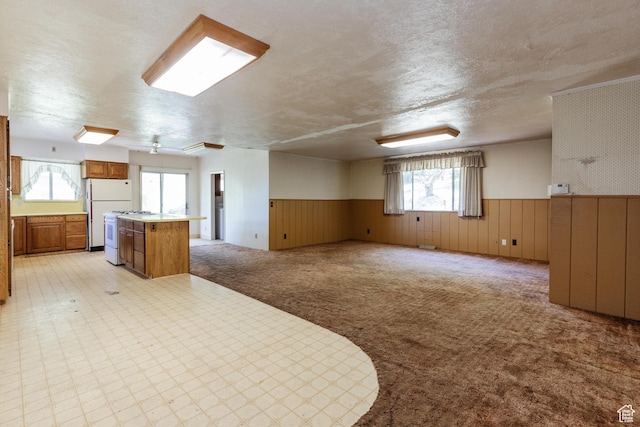 85 E 500 S, Providence, UT 84332 - kitchen with a wainscoted wall, a center island, a textured ceiling, brown cabinetry, and open floor plan