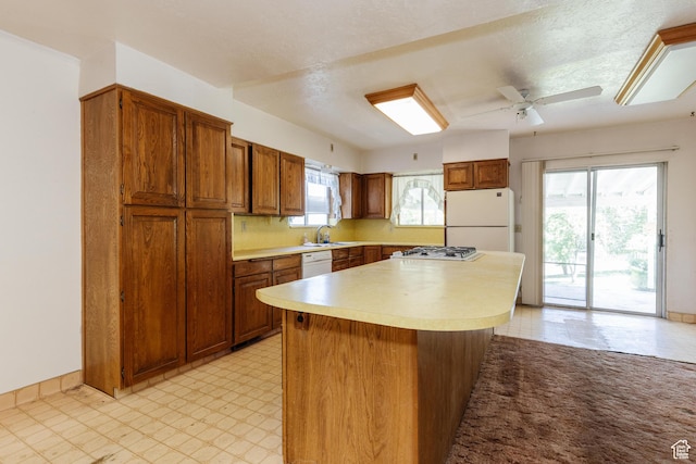 85 E 500 S, Providence, UT 84332 - kitchen featuring white appliances, brown cabinets, light countertops, and a center island