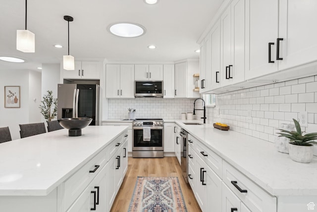 932 W Walden Meadows Dr S, Salt Lake City, UT 84123 - kitchen with stainless steel appliances, light wood-style floors, a center island, white cabinets, and recessed lighting
