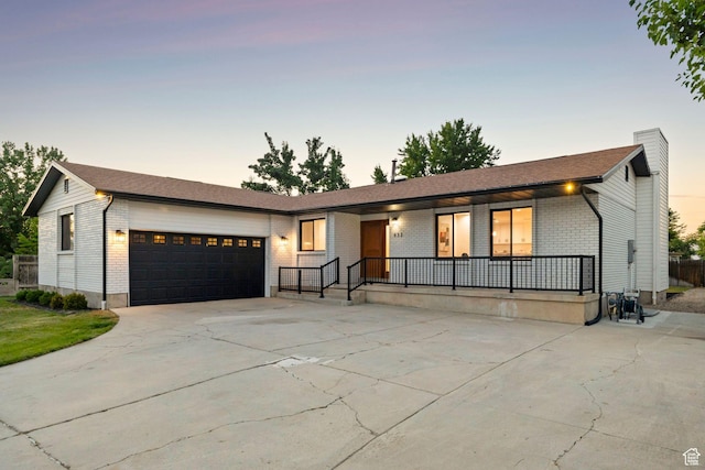 932 W Walden Meadows Dr S, Salt Lake City, UT 84123 - view of front of house with brick siding, a garage, covered porch, concrete driveway, and a chimney