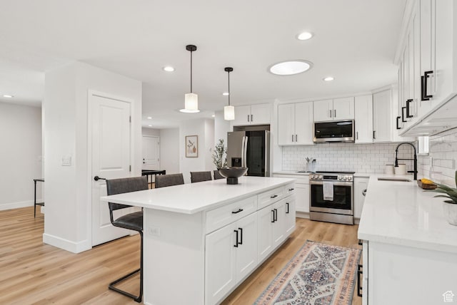 932 W Walden Meadows Dr S, Salt Lake City, UT 84123 - kitchen with stainless steel appliances, a breakfast bar area, tasteful backsplash, light wood finished floors, and white cabinets
