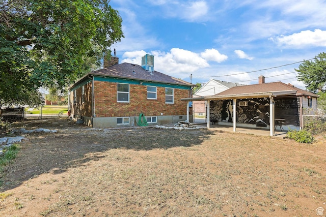 437 E 100 N, Brigham City, UT 84302 - back of house with a chimney, brick siding, a patio, and a yard