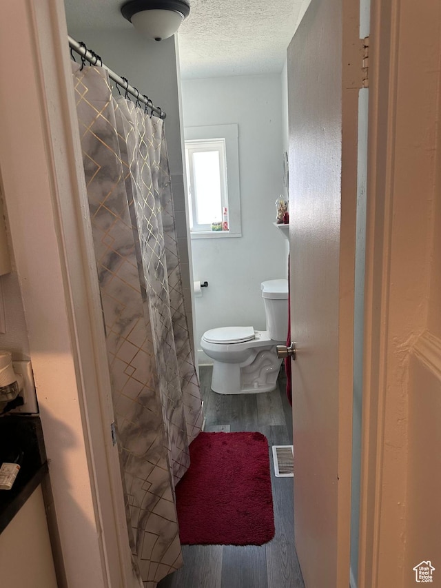 2019 Adams Ave, Ogden, UT 84401 - full bathroom with wood finished floors, a textured ceiling, and curtained shower