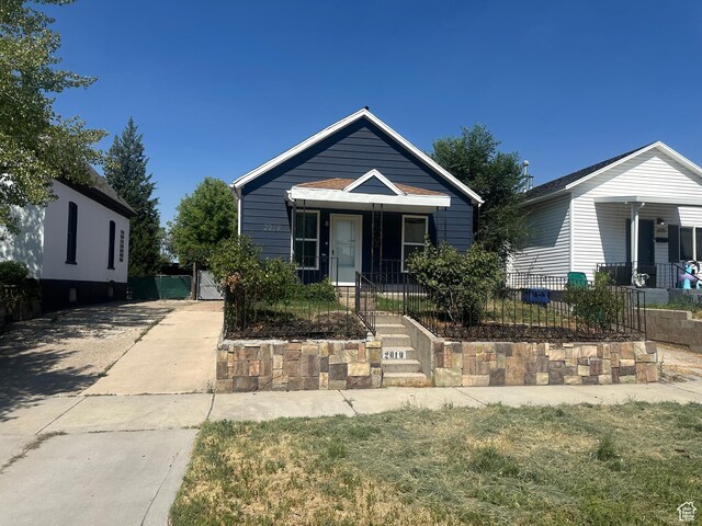 2019 Adams Ave, Ogden, UT 84401 - view of front facade with a fenced front yard, covered porch, concrete driveway, and a gate