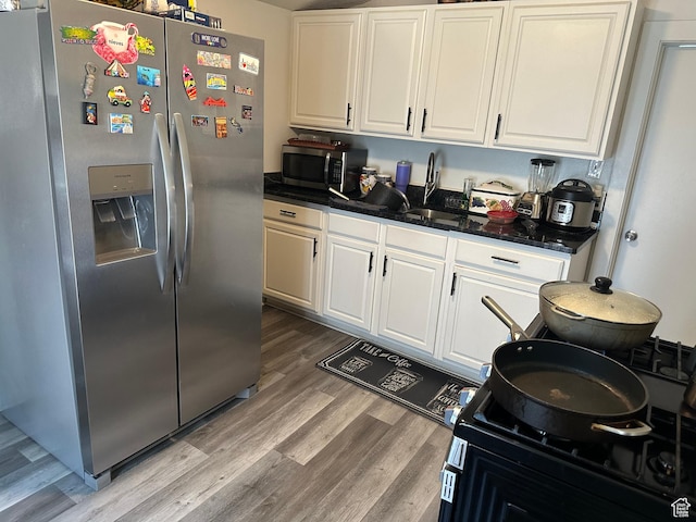 2019 Adams Ave, Ogden, UT 84401 - kitchen with stainless steel appliances, light wood finished floors, white cabinetry, and dark stone countertops
