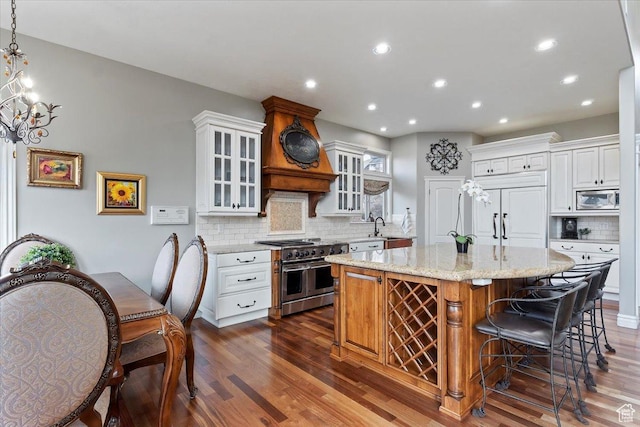 1711 N Compton Rd, Farmington, UT 84025 - kitchen with built in appliances, dark wood-type flooring, tasteful backsplash, light stone countertops, and a kitchen island