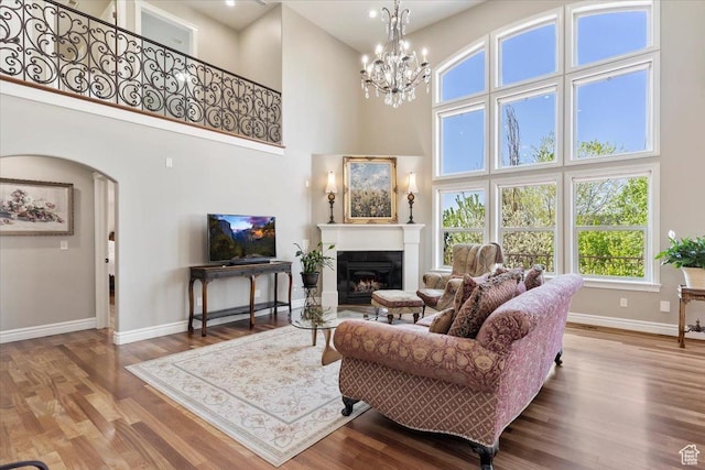 1711 N Compton Rd, Farmington, UT 84025 - living area with a towering ceiling, wood finished floors, a glass covered fireplace, arched walkways, and a chandelier