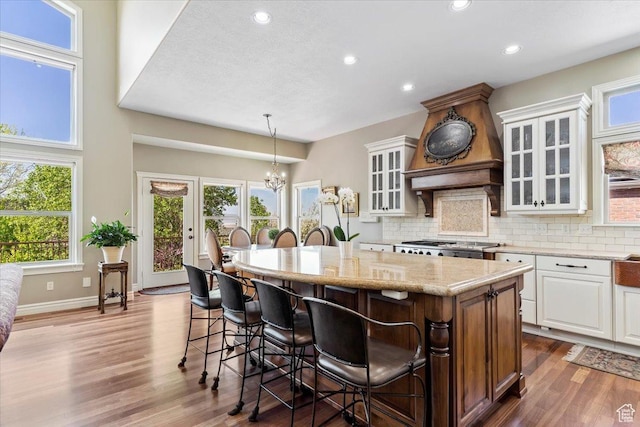 1711 N Compton Rd, Farmington, UT 84025 - kitchen featuring a breakfast bar, white cabinetry, a kitchen island, plenty of natural light, and recessed lighting