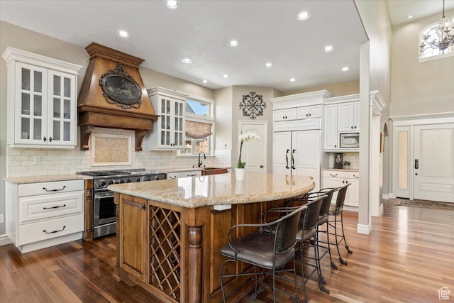 1711 N Compton Rd, Farmington, UT 84025 - kitchen featuring built in appliances, dark wood-type flooring, a kitchen island, light stone counters, and recessed lighting